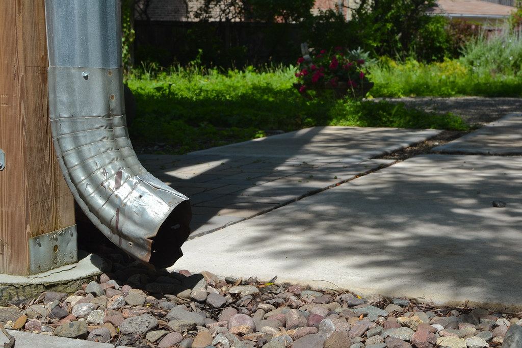 Downspout discharging at rear foundation